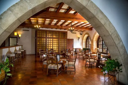 Salón del Parador de Tortosa con arcos de piedra y vigas de madera